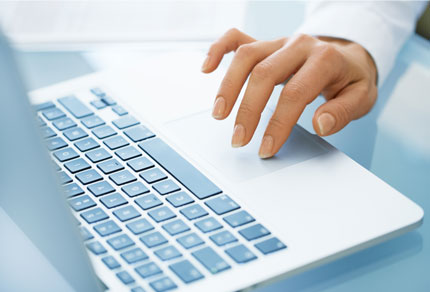 Close up of a hand using the trackpad on a laptop.