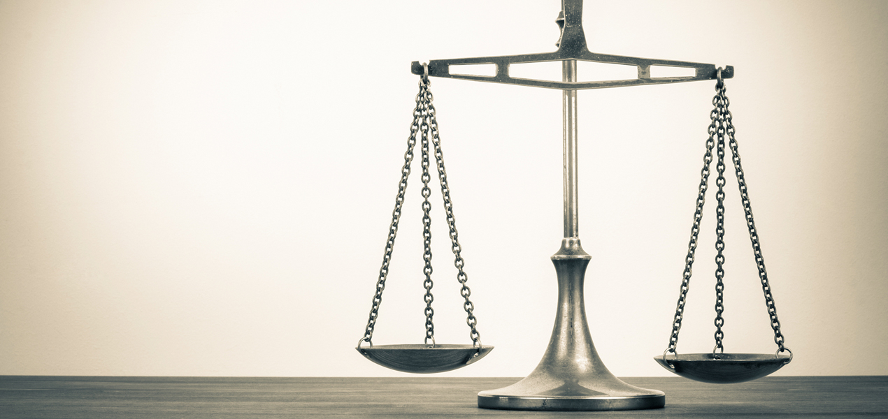 Scales of Justice with a simple beige background.