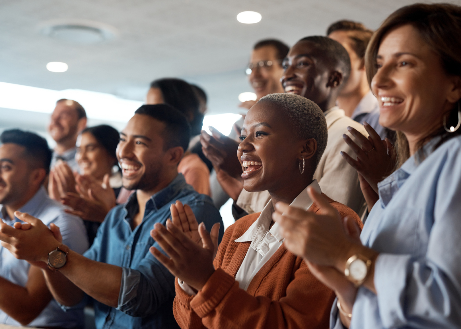 A diverse group of colleagues clapping and cheering.