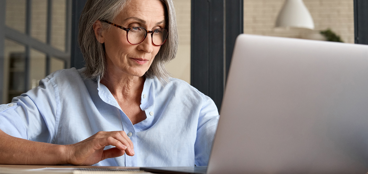 A mature woman working on a laptop.